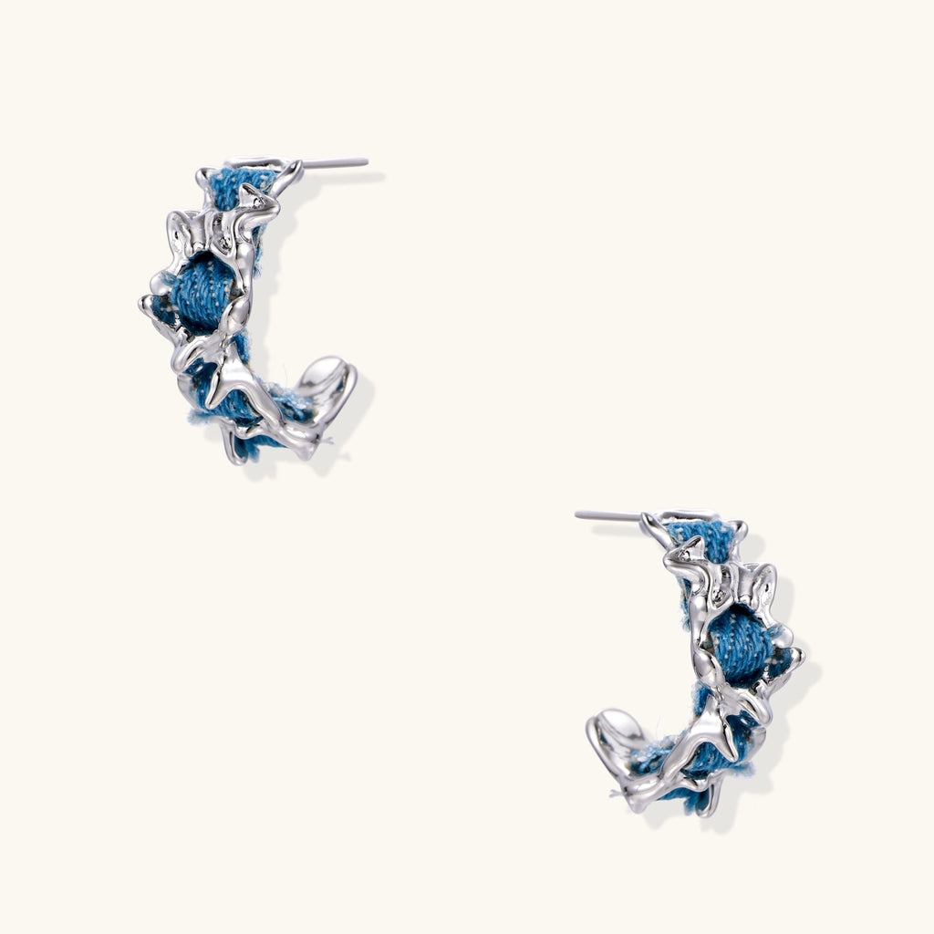 White gold plated hoop earrings with woven blue denim fabric through organic branch-like metal framework